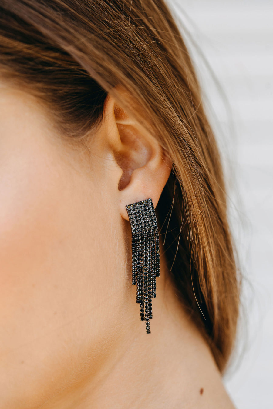 Styled image of our Equinox earrings being worn by brunette woman.